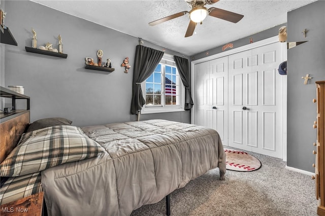 carpeted bedroom with a closet, baseboards, a textured ceiling, and ceiling fan