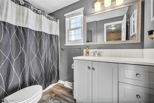 full bathroom with a shower with curtain, toilet, wood finished floors, baseboards, and vanity