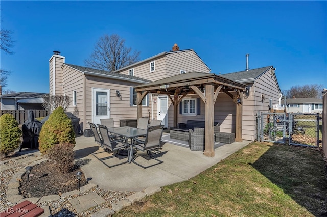 rear view of property with fence, a gazebo, a chimney, a patio, and a gate