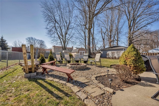 view of yard featuring an outdoor structure, fence, a shed, and an outdoor fire pit