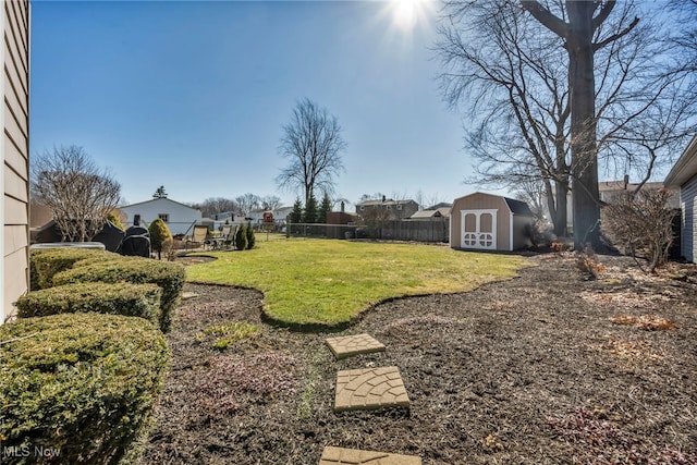 view of yard featuring a storage shed, a fenced backyard, and an outdoor structure