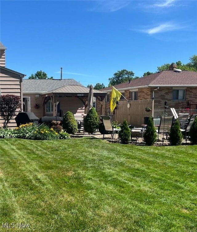 back of property featuring a yard, a patio area, and fence