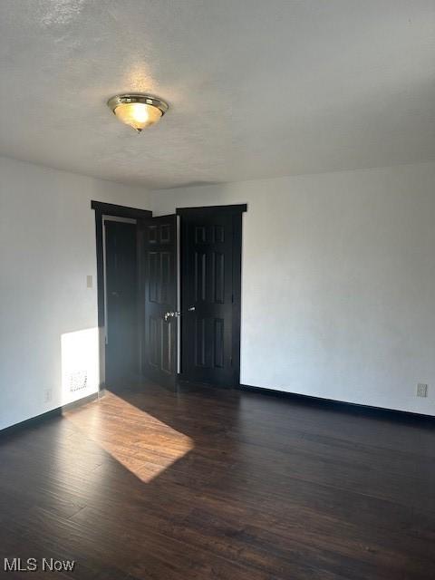 unfurnished room with visible vents, baseboards, and wood finished floors