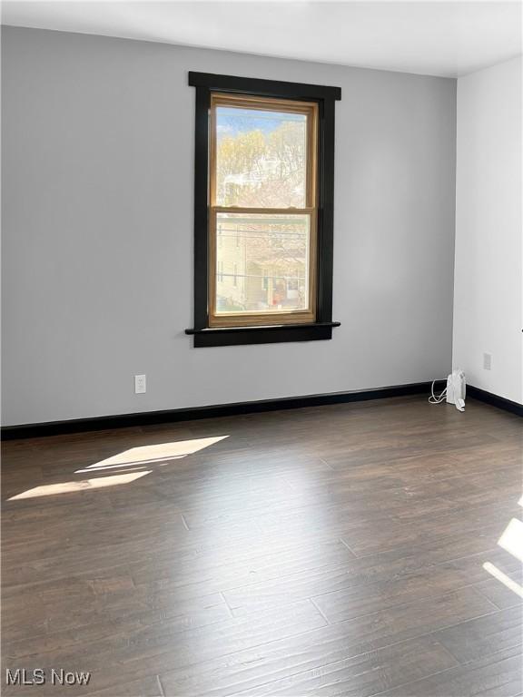 unfurnished room featuring baseboards and wood finished floors