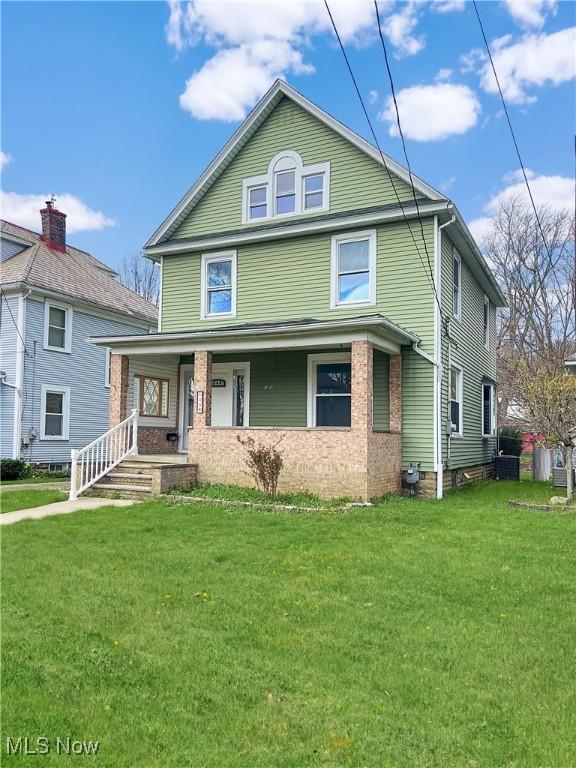 american foursquare style home with a front lawn and a porch
