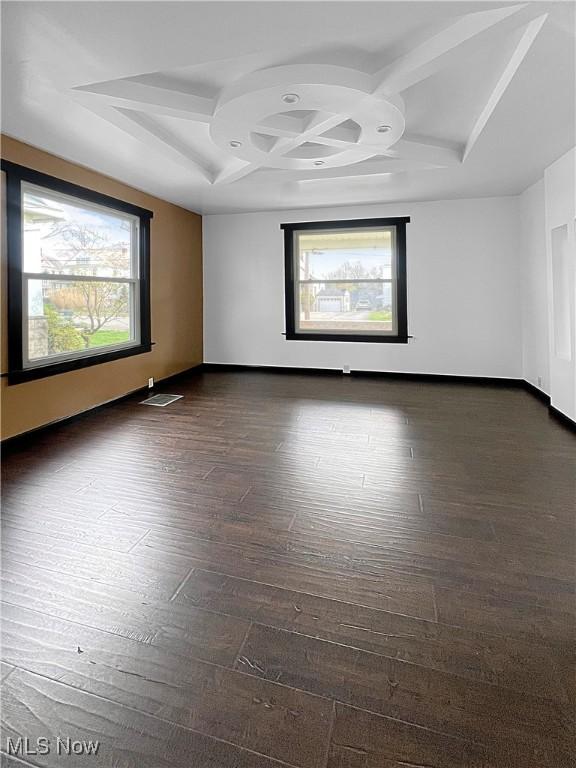 unfurnished room with dark wood finished floors, coffered ceiling, baseboards, and a wealth of natural light