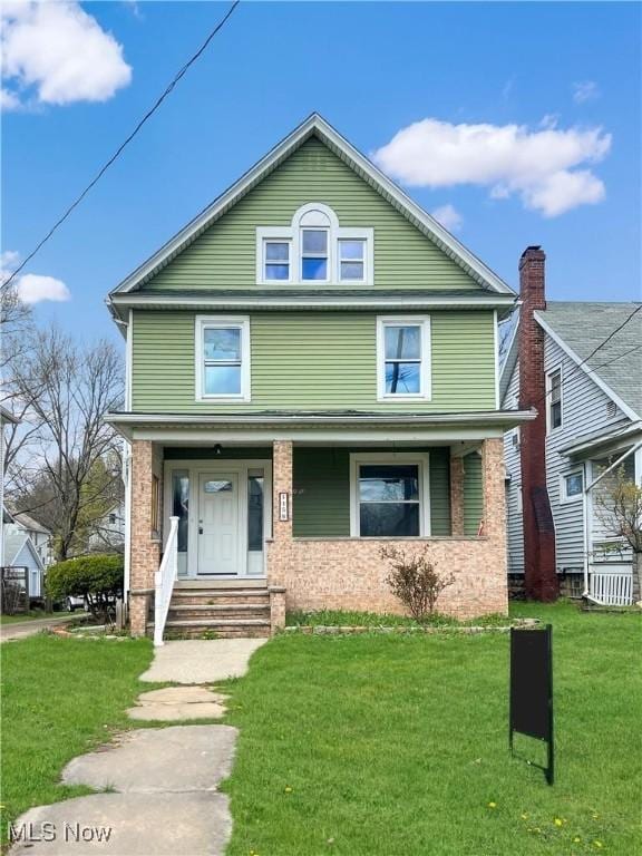 traditional style home featuring a porch and a front yard
