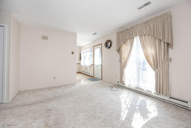 spare room with a baseboard heating unit, light colored carpet, visible vents, and a baseboard radiator