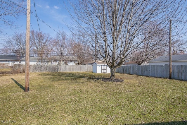 view of yard with an outbuilding, a shed, and fence