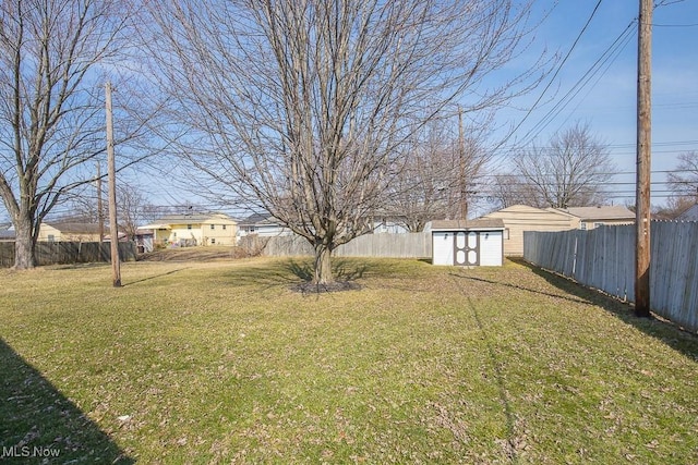 view of yard with a storage unit, an outbuilding, and a fenced backyard