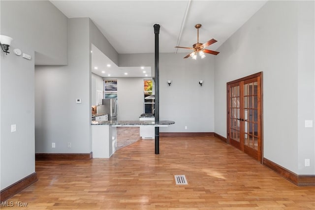 unfurnished living room featuring baseboards, light wood-style floors, visible vents, and ceiling fan