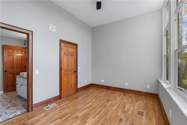 unfurnished bedroom featuring light wood-type flooring, visible vents, and baseboards