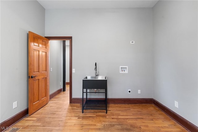 washroom featuring light wood-type flooring, washer hookup, laundry area, hookup for an electric dryer, and a sink