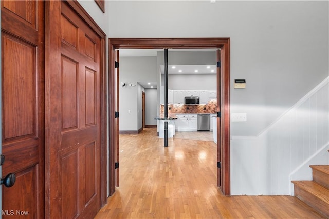 corridor with stairway and light wood-type flooring