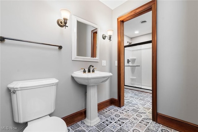 bathroom featuring visible vents, a shower stall, toilet, and baseboards