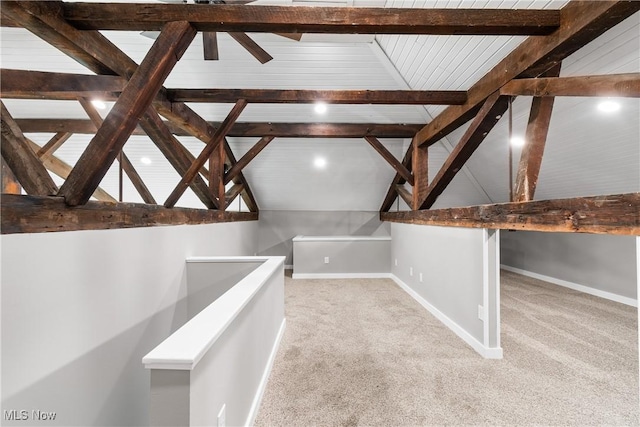 interior space with vaulted ceiling with beams, baseboards, and carpet floors