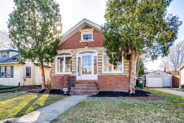 view of front of property featuring brick siding, entry steps, a front lawn, and an outdoor structure