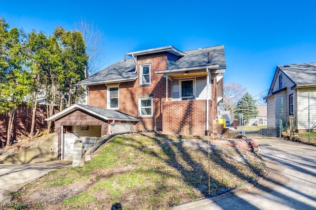 view of front of home featuring a gate, brick siding, driveway, and roof with shingles