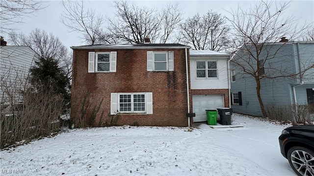 view of front of house featuring a garage, brick siding, and a chimney