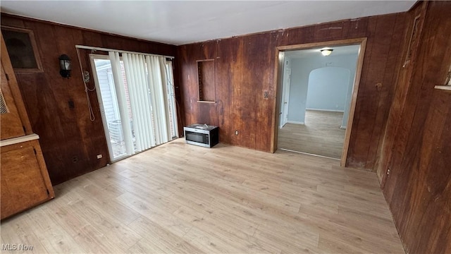 interior space with wooden walls and light wood finished floors