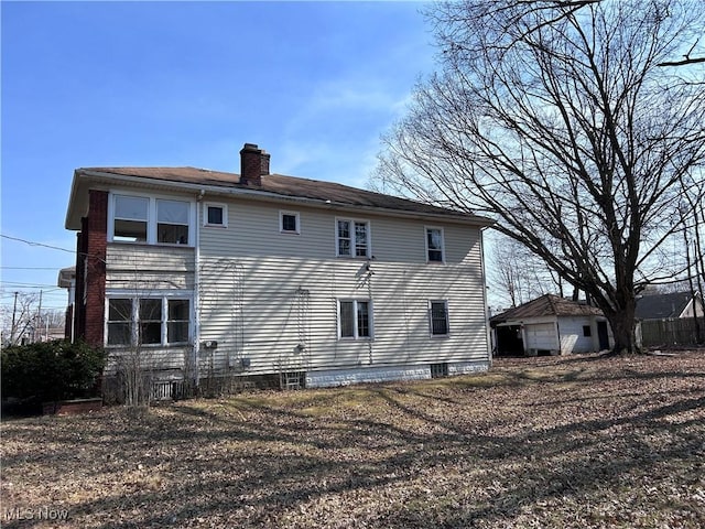 back of house featuring a chimney