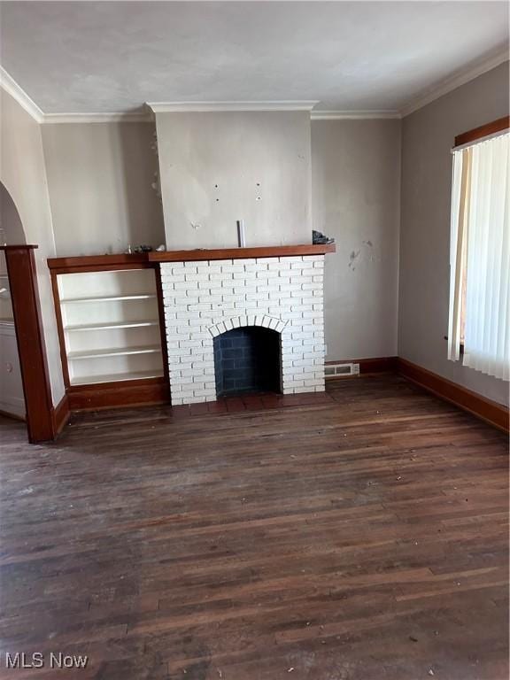 unfurnished living room with visible vents, ornamental molding, wood finished floors, baseboards, and a brick fireplace