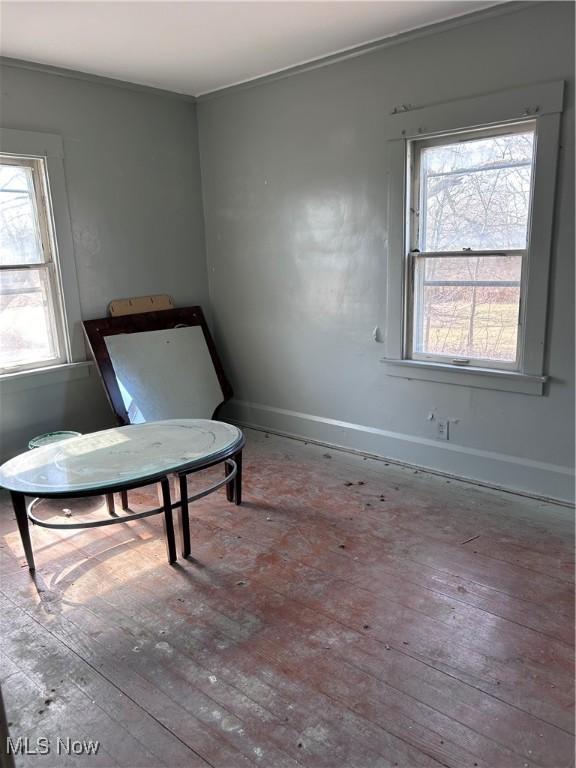 interior space featuring a wealth of natural light, baseboards, crown molding, and hardwood / wood-style flooring