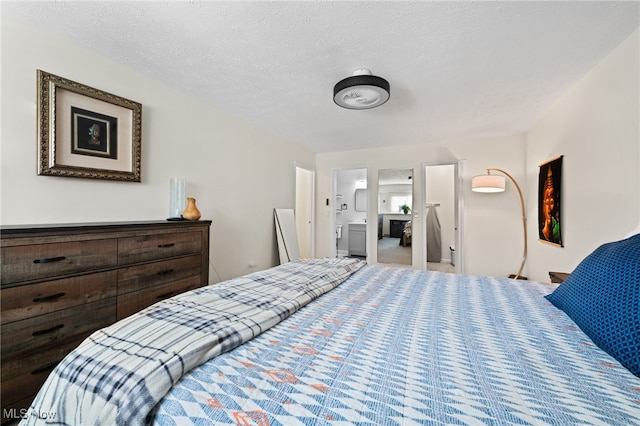 bedroom with ensuite bath and a textured ceiling