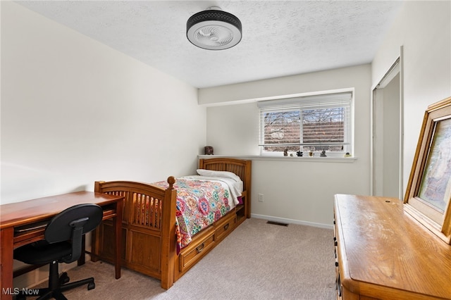 carpeted bedroom featuring visible vents, baseboards, and a textured ceiling