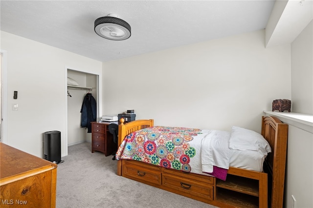 bedroom with a closet and light carpet