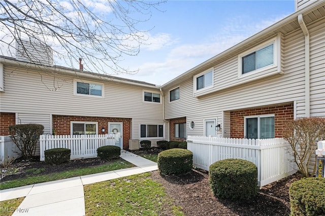 townhome / multi-family property featuring brick siding and fence