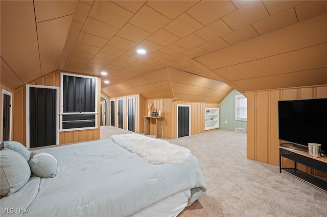 carpeted bedroom with visible vents, lofted ceiling, and wooden walls