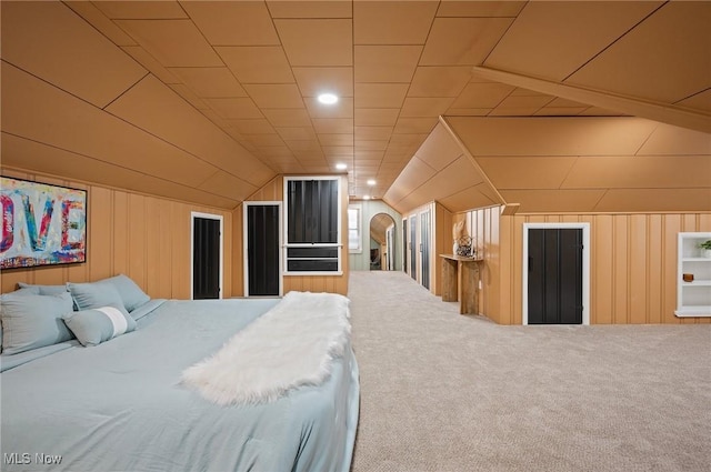 carpeted bedroom featuring lofted ceiling and wooden walls