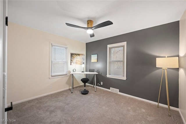 office area featuring visible vents, carpet flooring, baseboards, and a ceiling fan