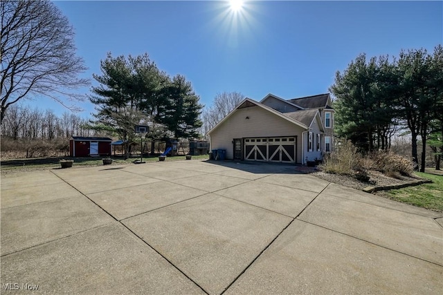 view of home's exterior with a garage, an outdoor structure, and concrete driveway