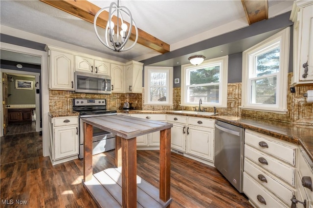 kitchen with a sink, stainless steel appliances, a healthy amount of sunlight, and dark wood-style floors