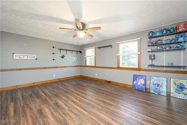 empty room featuring baseboards, a textured ceiling, wood finished floors, and a ceiling fan