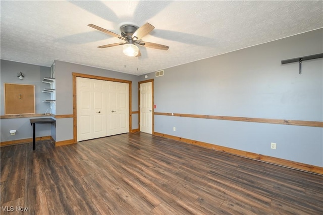 unfurnished bedroom with visible vents, a textured ceiling, baseboards, and wood finished floors