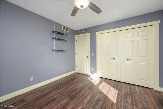 unfurnished bedroom featuring visible vents, a textured ceiling, wood finished floors, a closet, and baseboards