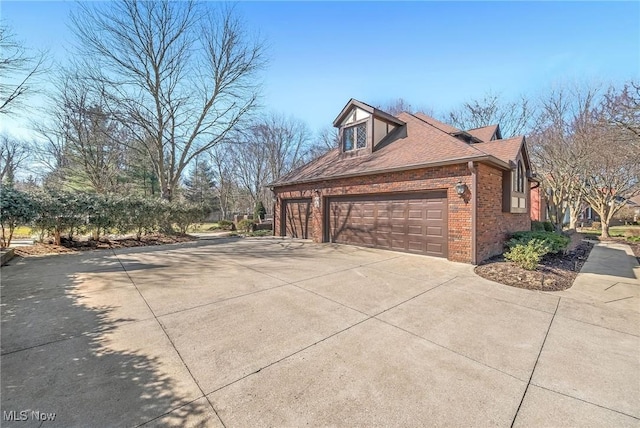 view of property exterior with an attached garage, brick siding, driveway, and a shingled roof