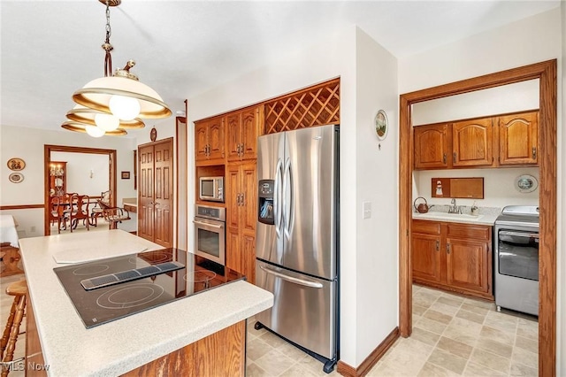 kitchen with appliances with stainless steel finishes, brown cabinetry, and light countertops