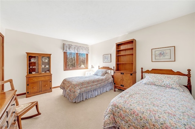 bedroom with baseboards and light carpet