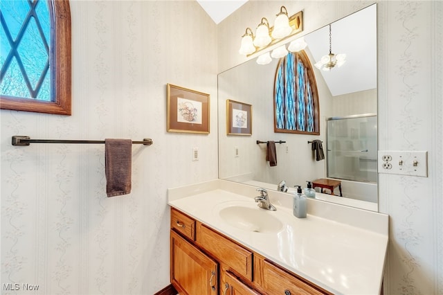 full bath with an enclosed shower, vaulted ceiling, vanity, and wallpapered walls