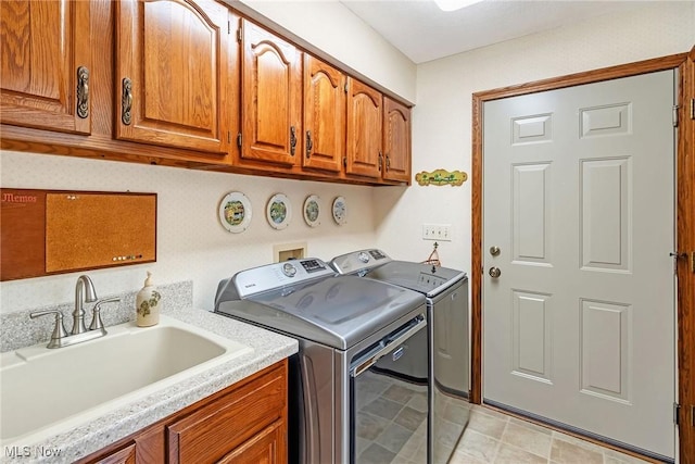 laundry room with cabinet space, washing machine and dryer, and a sink