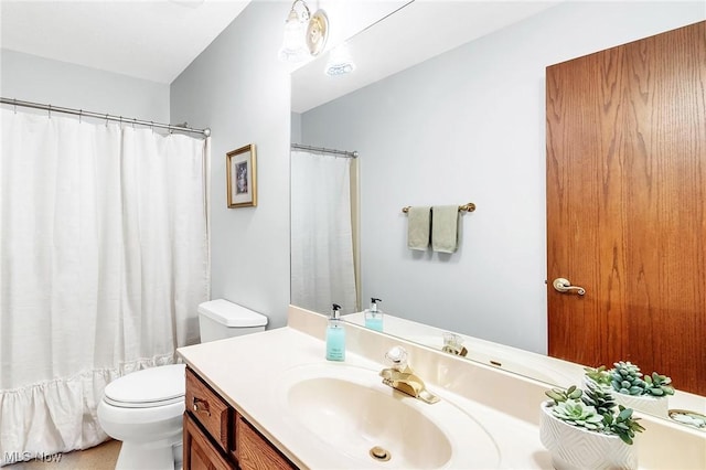 bathroom with curtained shower, toilet, and vanity