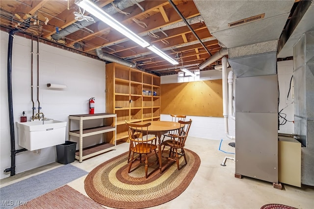 dining space featuring visible vents, concrete flooring, and concrete block wall