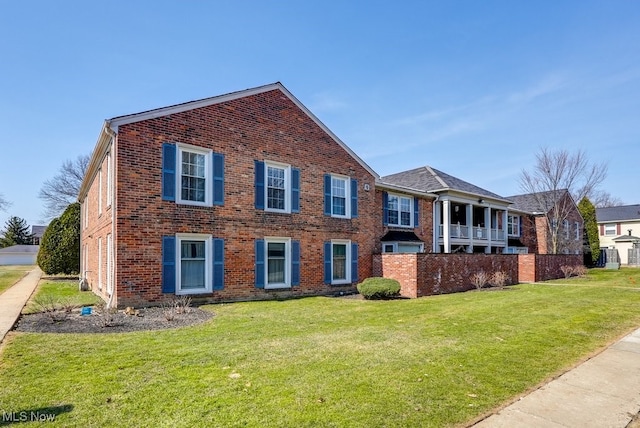 view of front of home with a front yard and brick siding