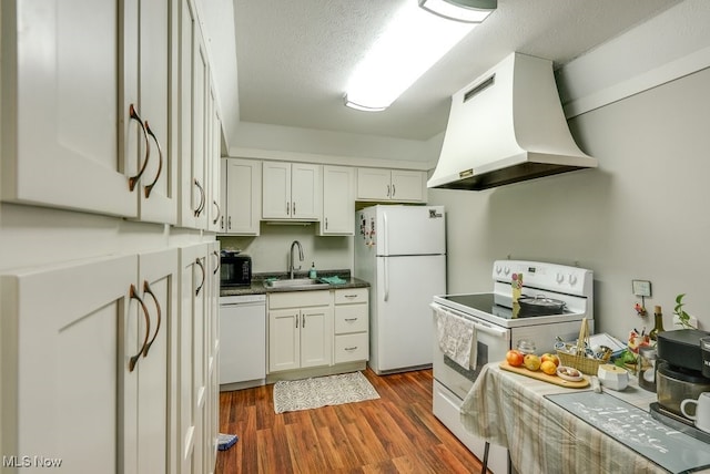 kitchen featuring dark countertops, a sink, extractor fan, white appliances, and dark wood-style flooring