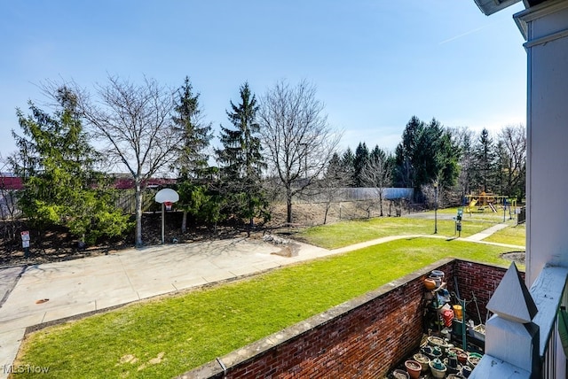 view of yard featuring playground community and fence