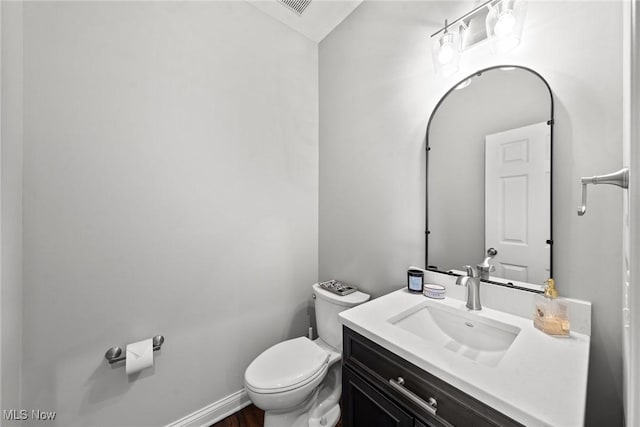 bathroom featuring toilet, vanity, and baseboards